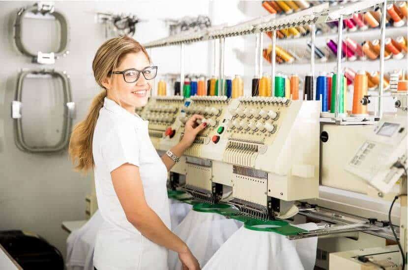 woman standing behind embroidery machine